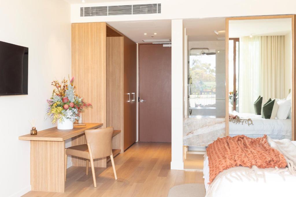 a bedroom with a desk and a bedroom with a bed at Reflections at Rich River in Moama