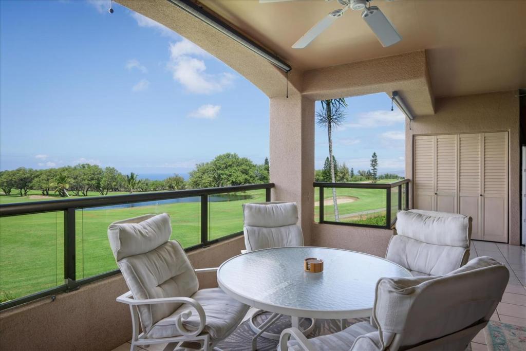a balcony with a table and chairs and a view at Waikoloa Fairways Unit A207 Golf Ocean View 2BD 2BA in Waikoloa Village