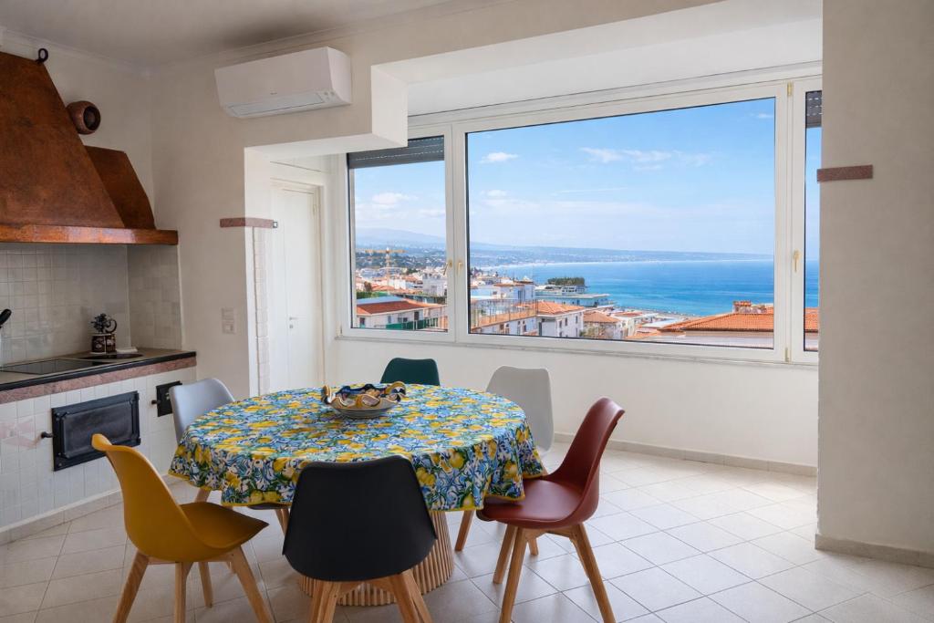 a kitchen and dining room with a table and a large window at Panoramic Apartment Sea & Vesuvio View, Sorrento Center, COSTA DEL SOLE in Sorrento