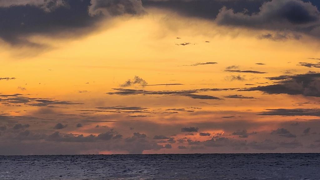 a sunset over the ocean with clouds in the sky at Bunkhouse Lodge in Omoa