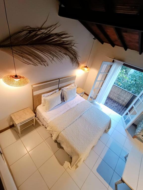 a bedroom with a bed and a large window at Palmares, Casa Rustica Suites Buzios in Búzios
