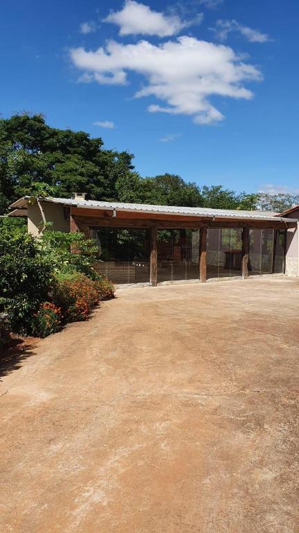 a building with a dirt yard in front of it at Camping e Pouso Recanto das Flores in Tiradentes