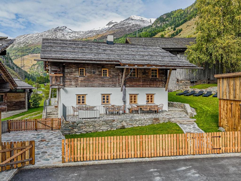 a house in the mountains with a wooden fence at Raneburg 4 in Matrei in Osttirol