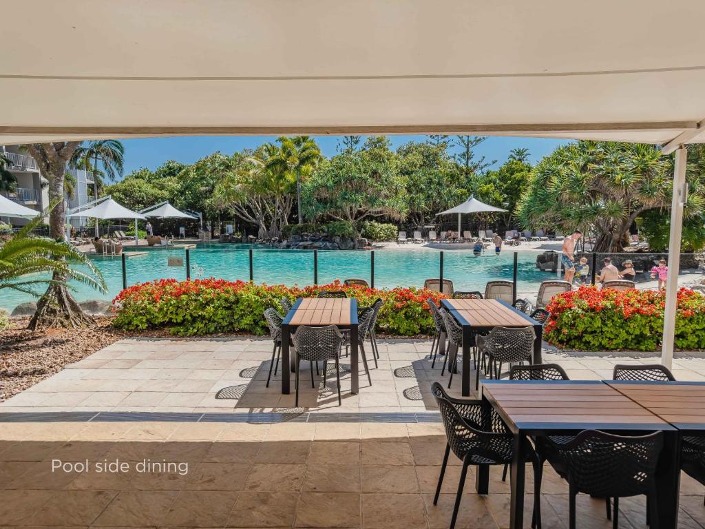 a patio with tables and chairs next to a pool at Salt Beach Resort Apartments by Kingscliff Accommodation in Kingscliff