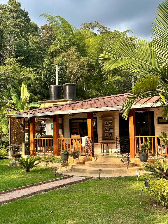 a house with a porch and a yard with trees at Finca Mi Fortuna - Con Piscina Privada y Vistas en La Mesa in La Mesa