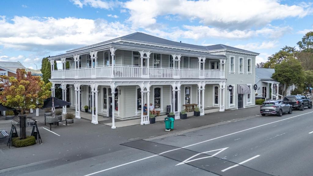 a white building with a balcony on a street at Altitude Apartment in Martinborough