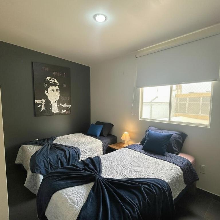 a room with two beds and a window at suite doble ejecutiva providencia in Guadalajara