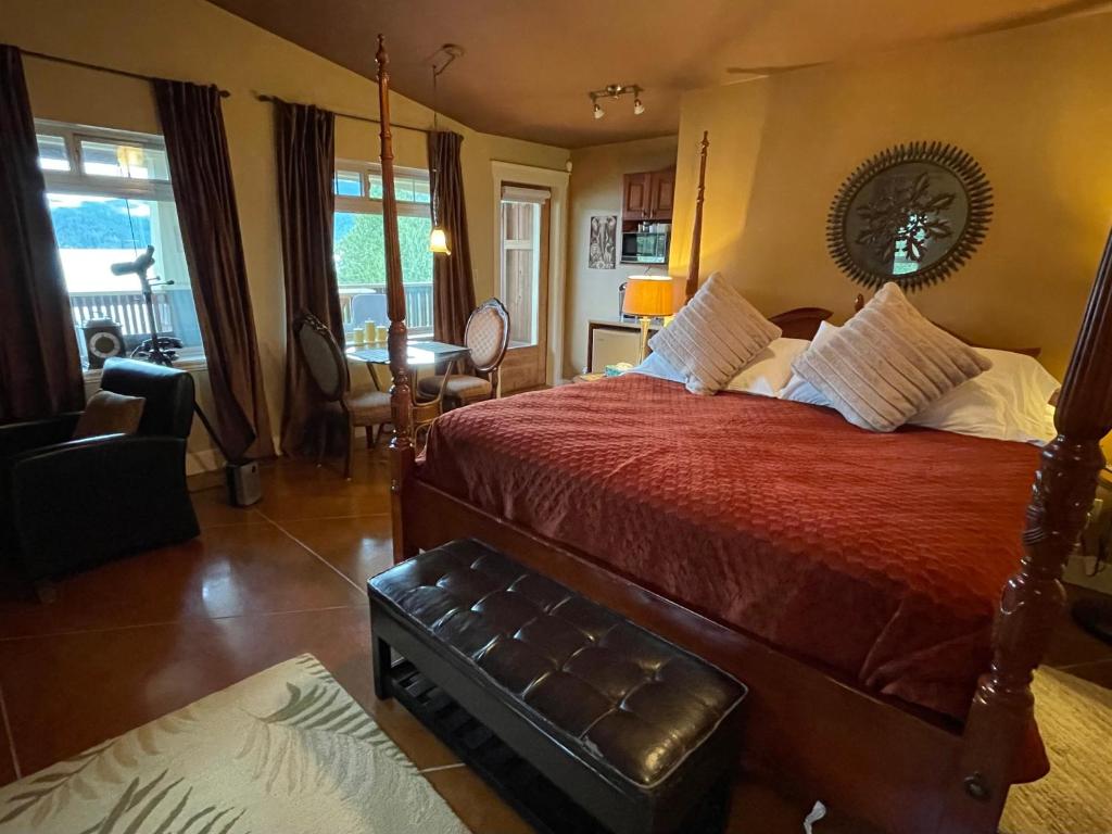 a bedroom with a bed with a red comforter at The Tuwanek Bed and Breakfast in Sechelt