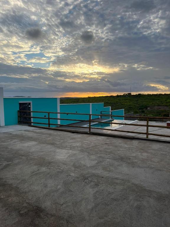 a blue building with a fence on the roof at chacara por do sol in Piranhas