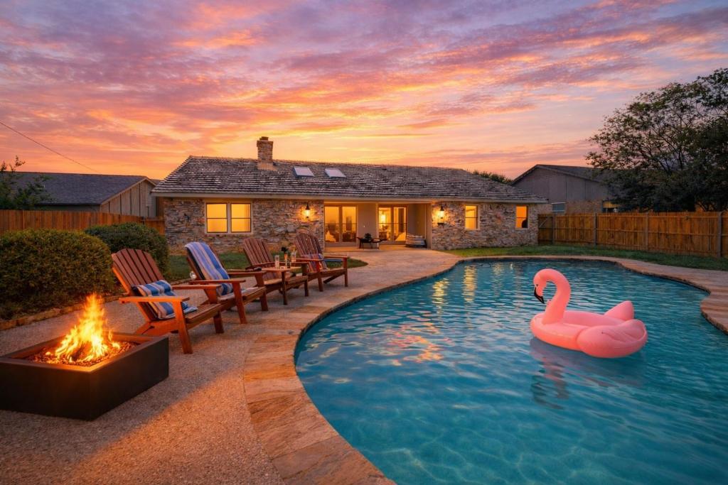 a swimming pool with two pink swans in a backyard at Stylish Villa-Near Stadiums, Large Pool,Pool Table in Bedford