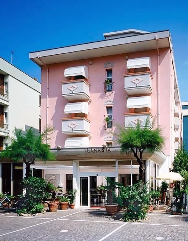 a pink building with plants in front of it at Hotel Canasta in Misano Adriatico
