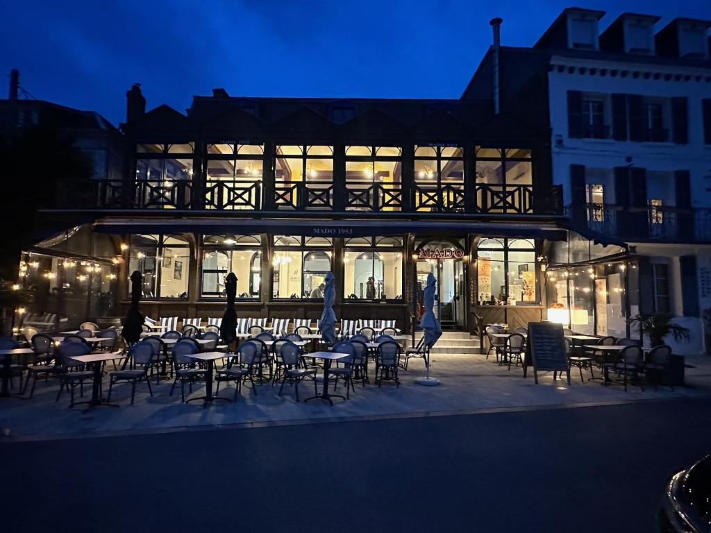 a restaurant with tables and chairs in front of a building at Mado by Scoop in Le Crotoy