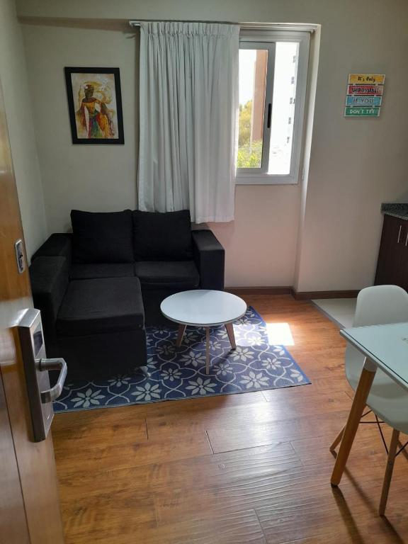 a living room with a black couch and a table at Loft Centro Cívico in San Juan