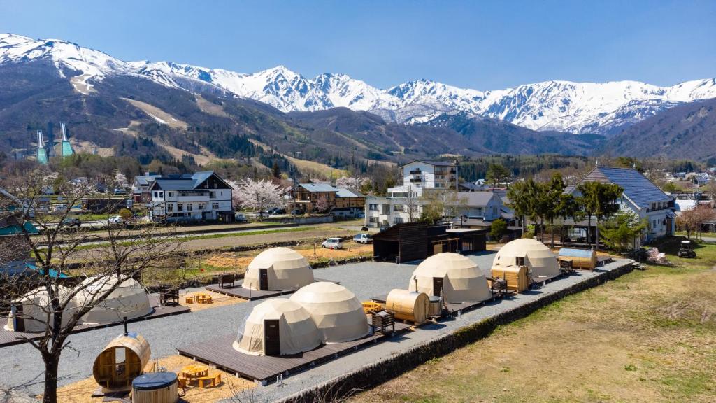 an aerial view of a town with snow covered mountains at From P in Hakuba