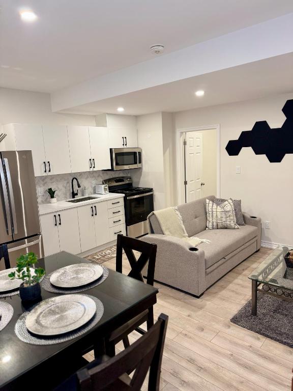 a kitchen and living room with a table and a couch at Spacious High Ceiling Lower Level Suite-New & Cozy in Vaughan
