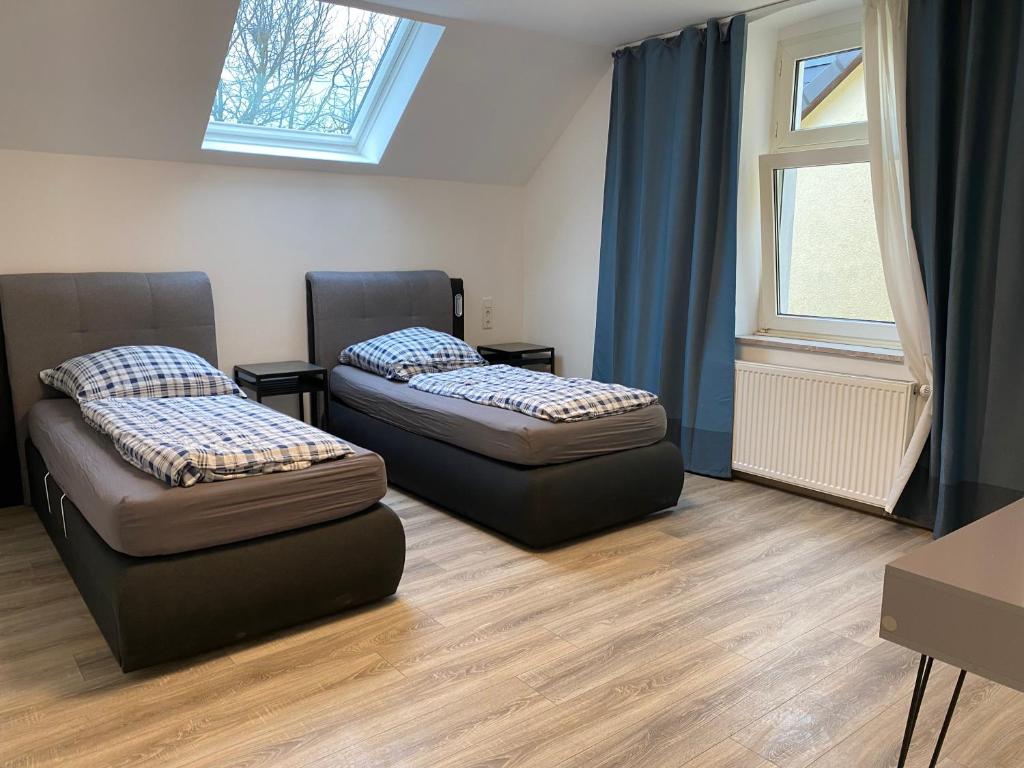 two beds in a room with a window at Ferienwohnung Modern 2 Rooms 4 Beds in Essen