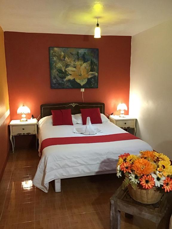 a bedroom with a large bed with red walls at Hotel Los Faroles, Villa del Carbón in Villa del Carbón