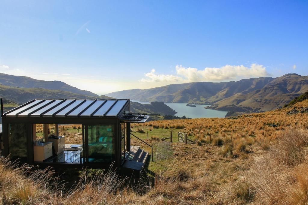a house on a hill with a view of a lake at Pōhue PurePod in Purau