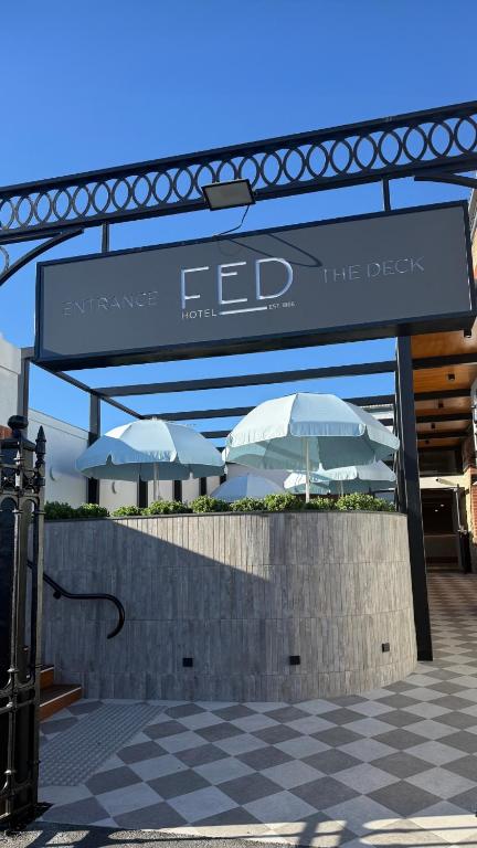 ein Schild mit Regenschirmen vor einem Gebäude in der Unterkunft Fed Hotel in Semaphore