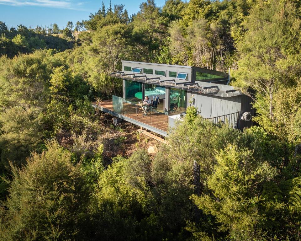 a house on the side of a hill with trees at Mākoha PurePod in Kerikeri
