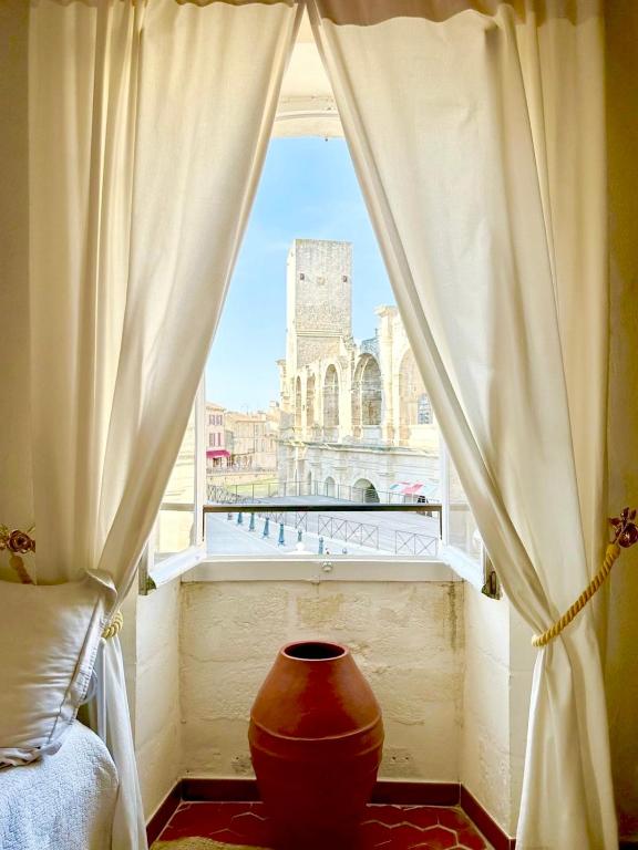 a window with a large vase in a room at Appartement aux Arènes in Arles
