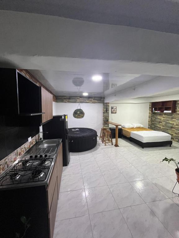 a kitchen with a stove and a couch in a room at Apartamento de lujo con jacuzzi en Jericó in Jericó
