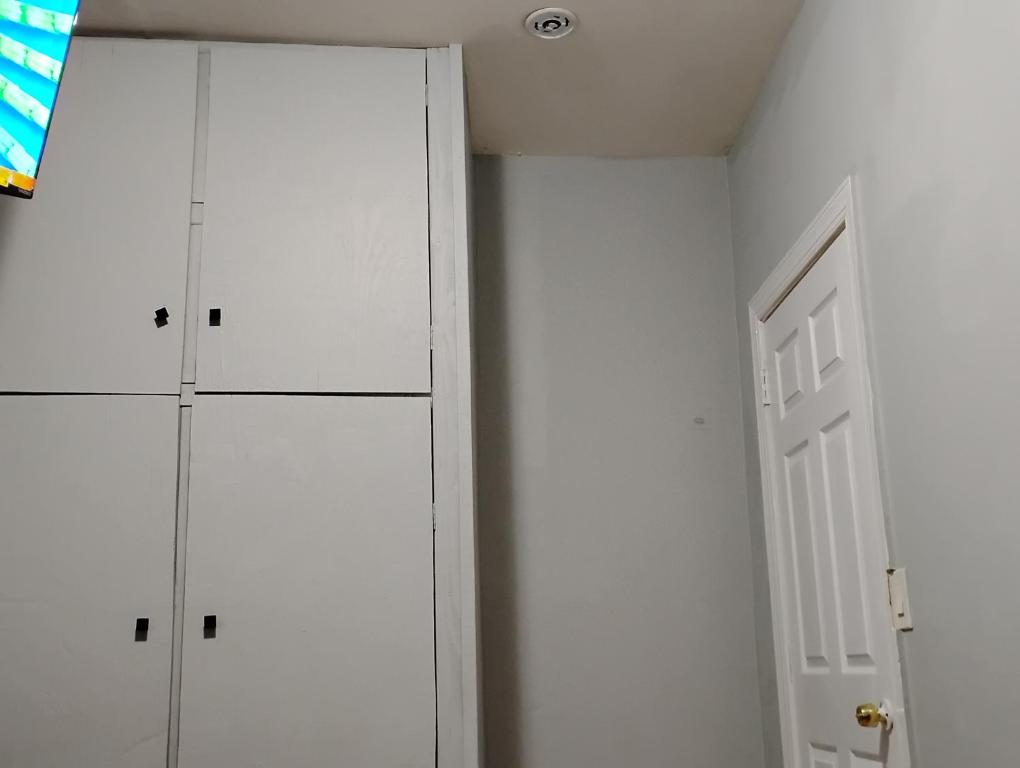 a room with two white cabinets and a door at Grove#10 in Irvington