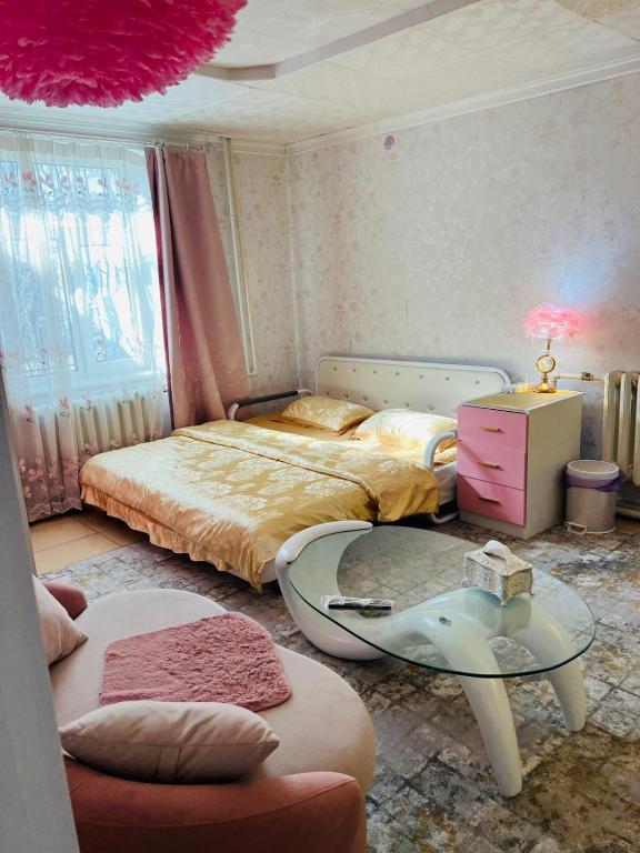 a bedroom with two beds and a glass table at Mandakh Naran Guest House in Dzuunmod