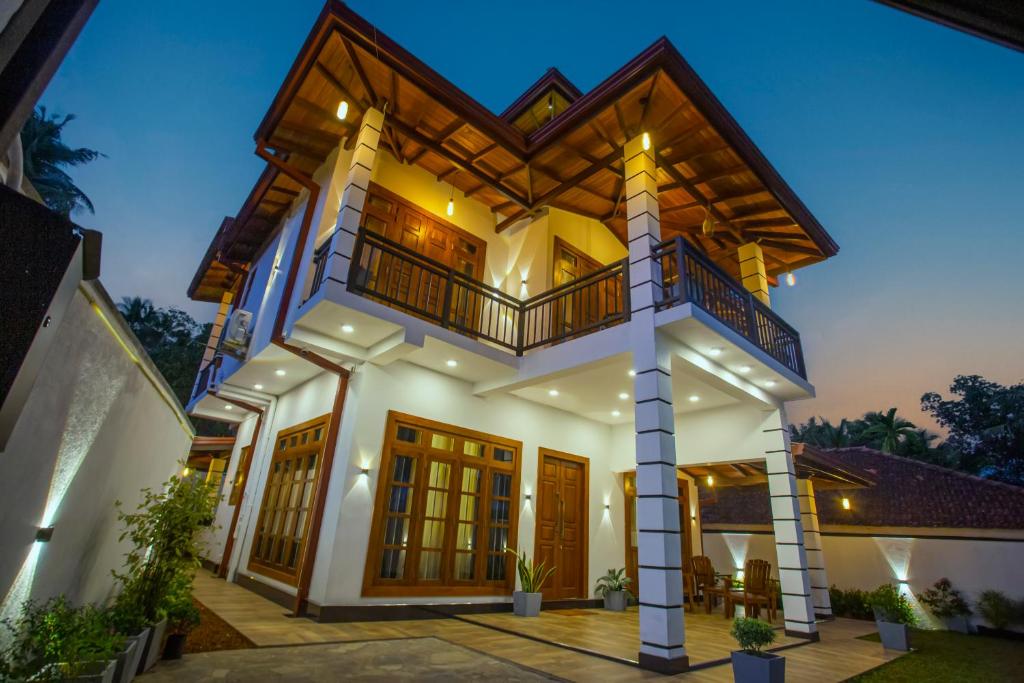 a large house with a balcony on top of it at Palms shede Villa in Habaraduwa Central