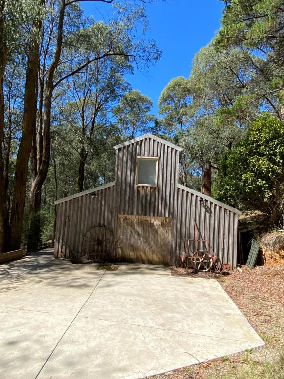 a small wooden shed with a window in it at The Barn Top Noojee in Noojee