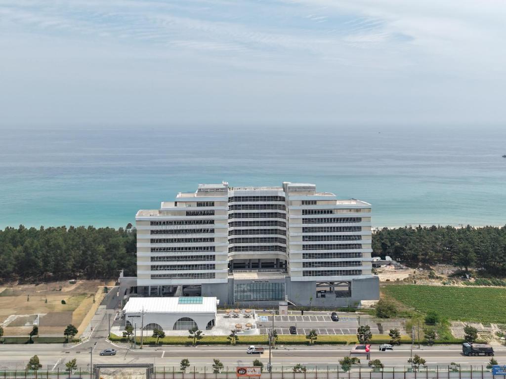 a large white building in front of the ocean at 블루앤호텔 in Songjŏng