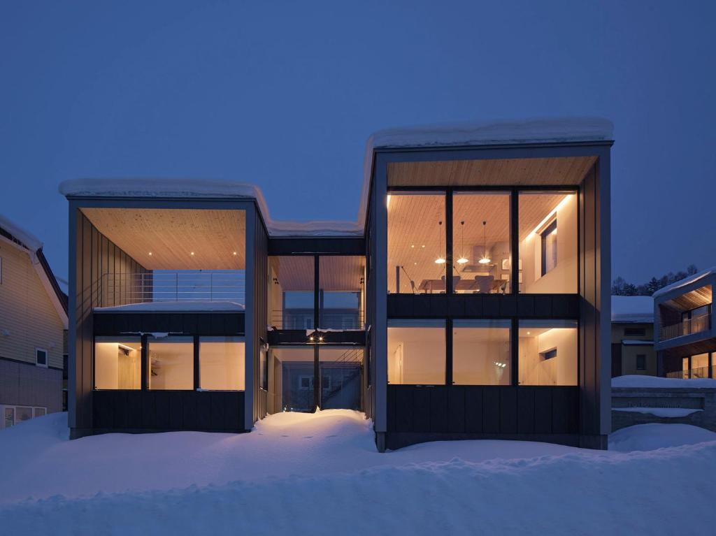 a building with large glass windows in the snow at TsuTsu Furano by H2 Life in Furano