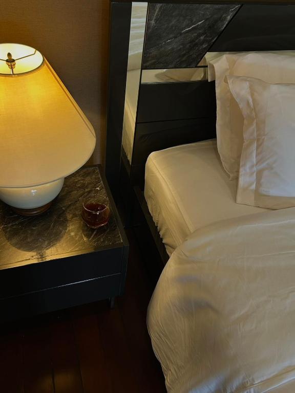 a bedroom with a bed and a lamp on a table at Base 22 Hatyai in Ban Rai