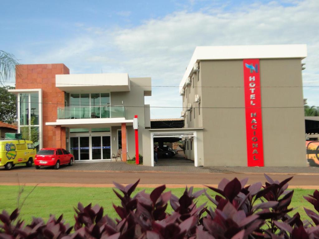 a building with a red sign in front of it at Hotel Nacional in Jataí