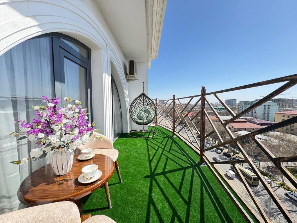 a balcony with a table with flowers on it at White House Apartment in Samarkand