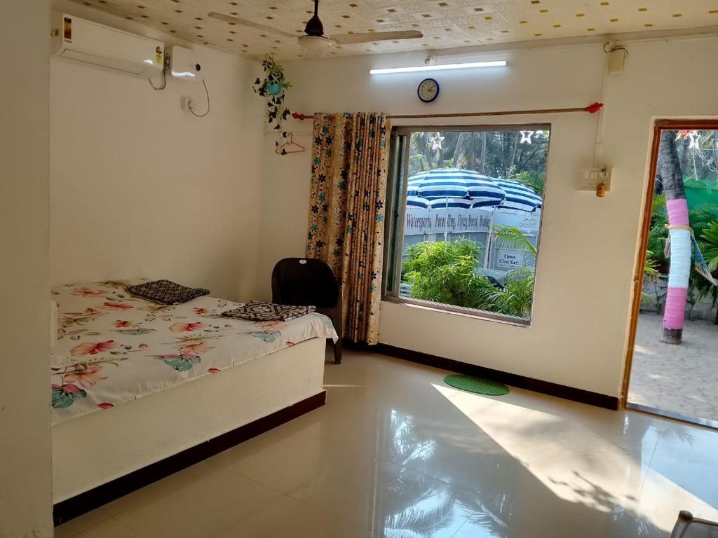 a bedroom with a bed and a window at Holiday Homestay Beach Rooms Deep Diving & Light House & Watersports Tarkarli in Bhogwe