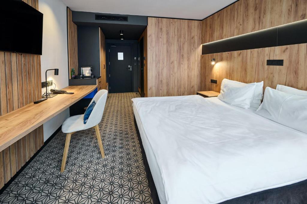 a hotel room with a large bed and a desk at Best Western Hotel Vista in Ostrava