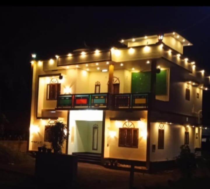 ein beleuchtetes Haus mit Lichtern auf dem Dach in der Unterkunft Tharavad Homestay Athirappilly in Athirappilly