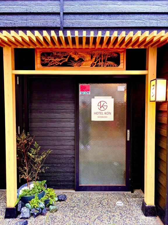 a front door of a building with a sign on it at Shinbashi Kon Hotel in Tokyo