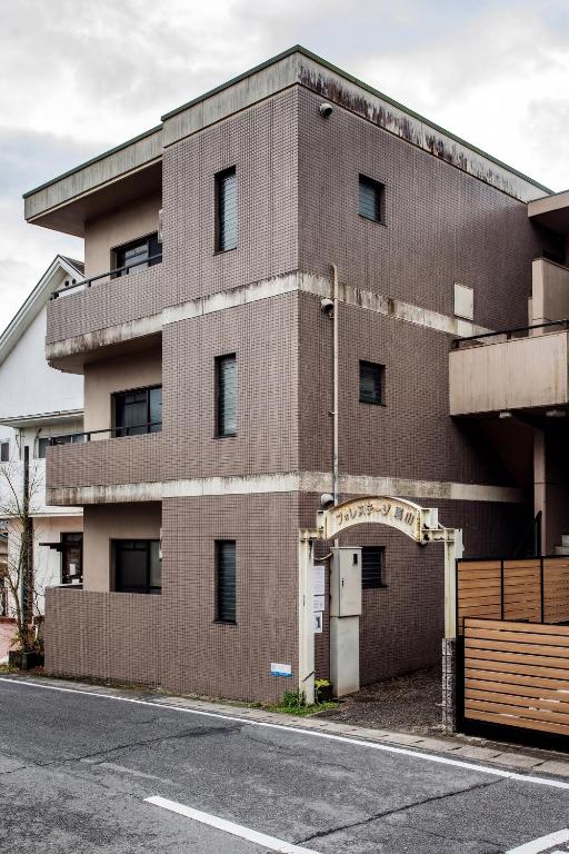a brown brick building with a gate in front of it at フォレステージ嵐山 in Kyoto