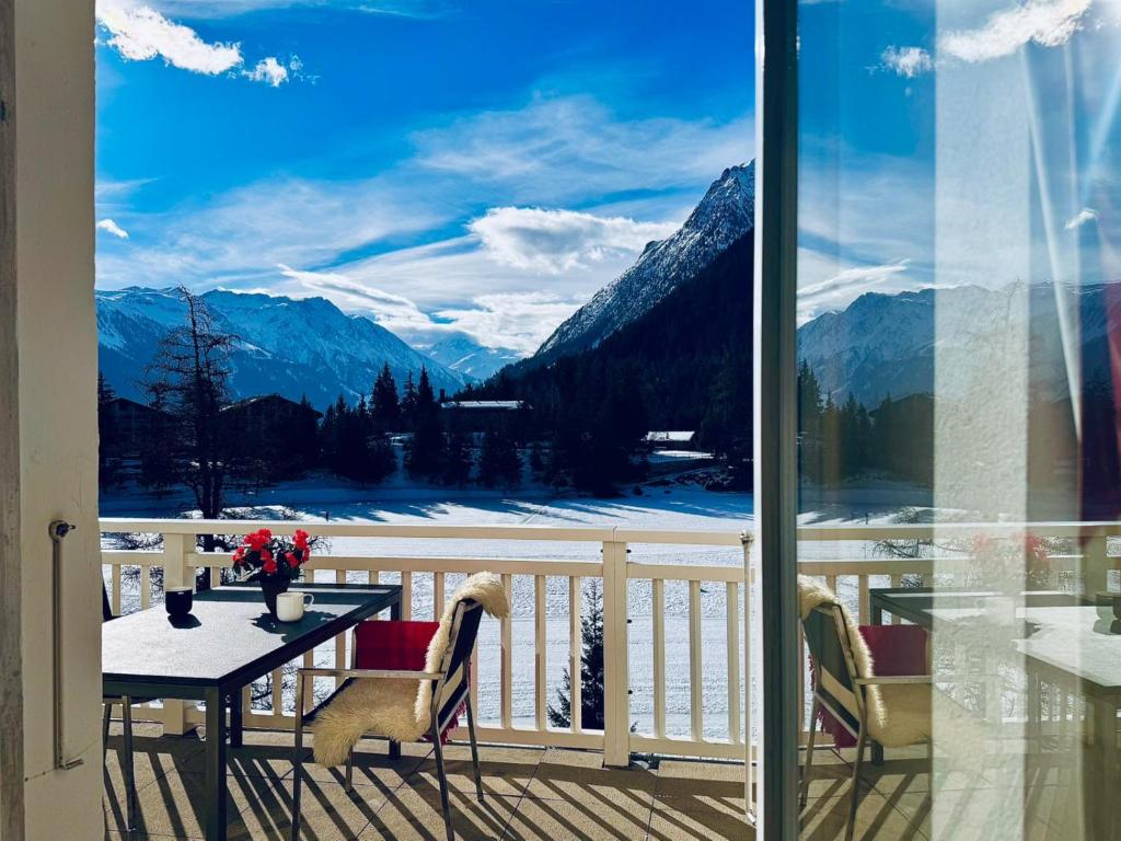 a balcony with a table and a view of mountains at Vache Mystique in Orsières