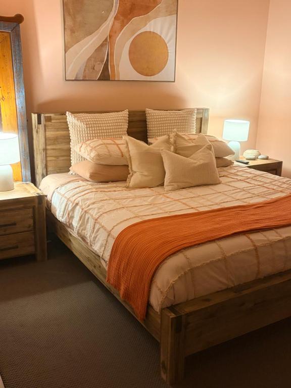 ein Schlafzimmer mit einem großen Bett und Kissen in der Unterkunft Rustic on 13th in Gawler