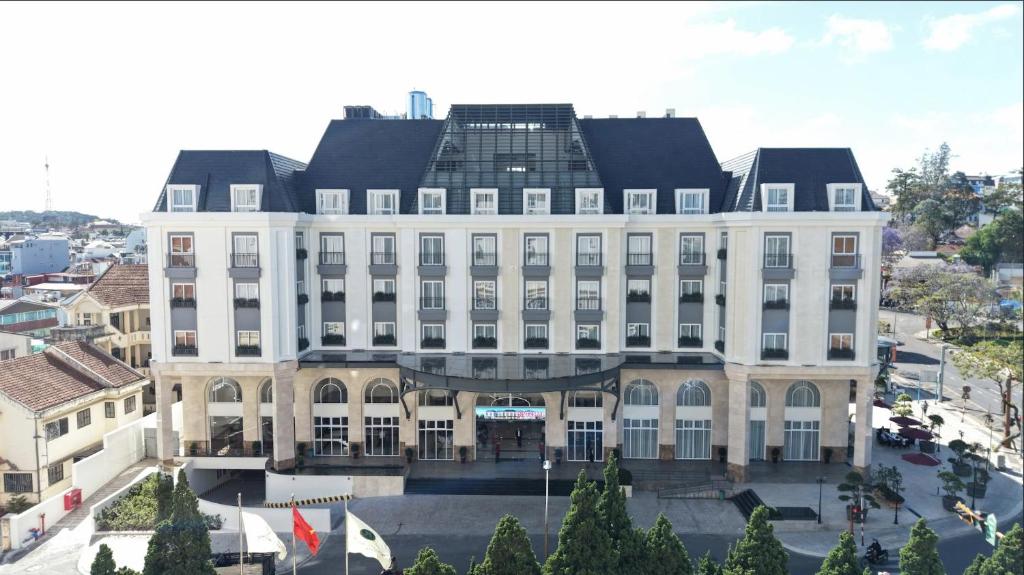 a large white building with a black roof at Sai Gon Da Lat Premium in Da Lat