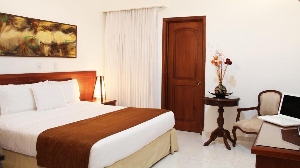 una camera con letto, scrivania e sedia di Hotel Tativan a Valledupar
