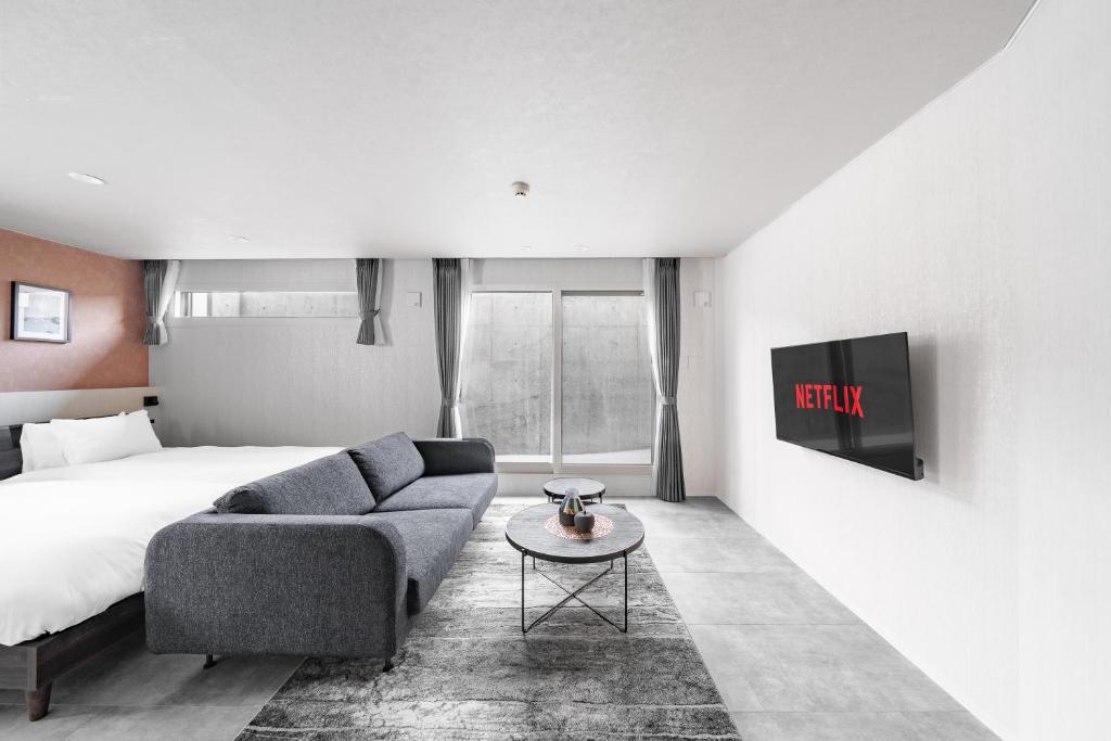 a hotel room with a couch and a bed at Gran Hills in Chitose