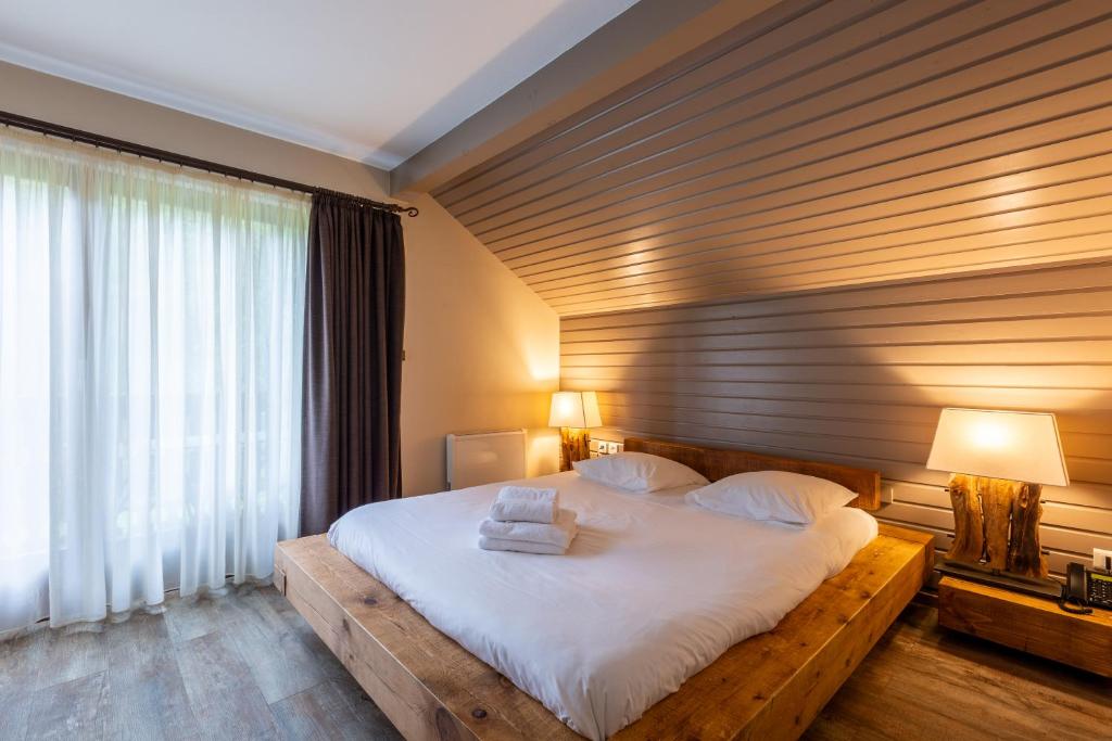a bedroom with a large bed with white sheets at Le Freudeneck in Wangenbourg