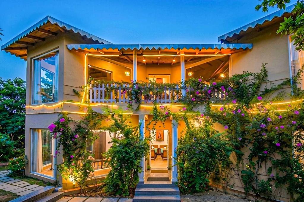 a house with flowers on the front of it at Mistletoe House by VEO - Part of StayVista in Bhīm Tāl