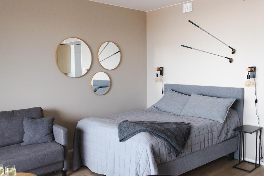 a bedroom with a bed and a chair and mirrors at Marinan Portin Svingi A23 lemmikit sallittu in Kalajoki