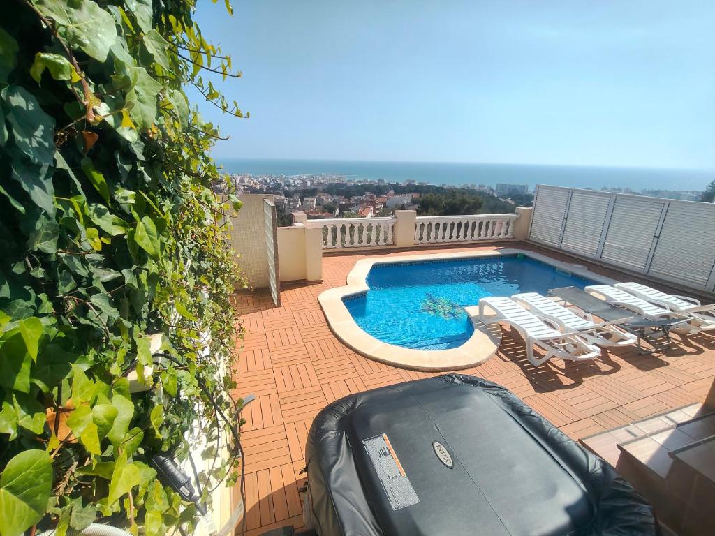 a balcony with a swimming pool and lounge chairs at BEACH HOUSE. CASA CON PISCINA PRIVADA in Calafell