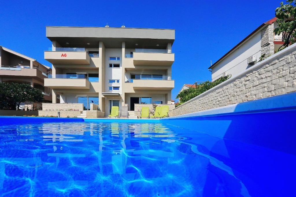 un edificio con piscina di fronte a un edificio di Luxury Apartments SIKIRIC with Fantastic View on the sea a Bibinje (Bibigne)